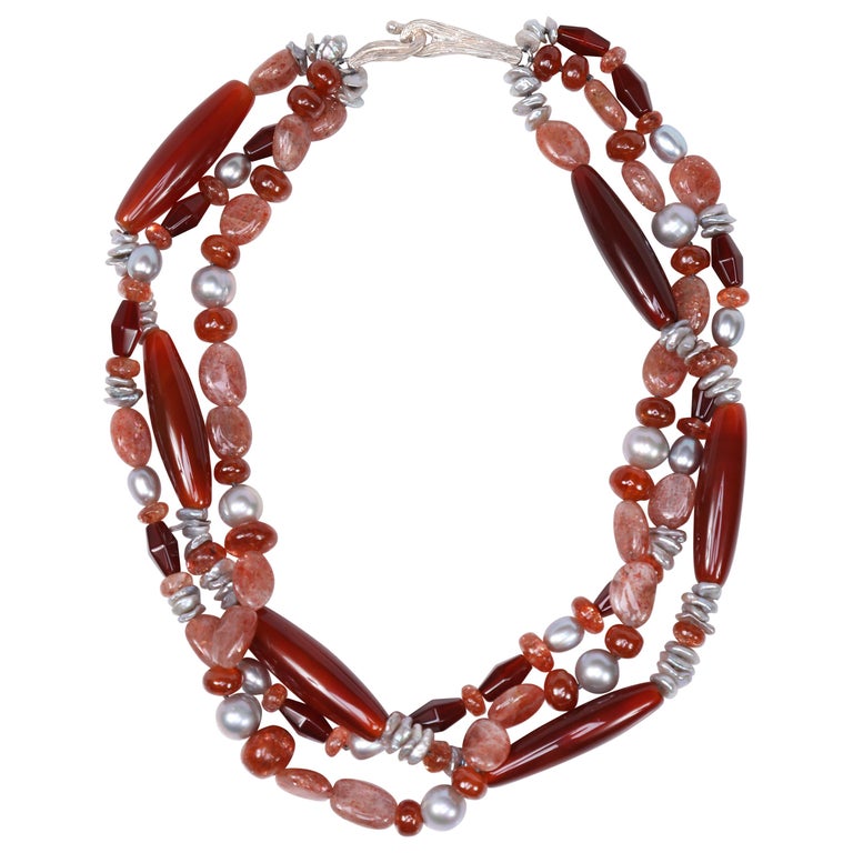 Sterling silver. Gems: carnelian, sunstone, and silver freshwater pearls. White Orchid Studio’s vanilla bean clasp. Approximate length: 18”