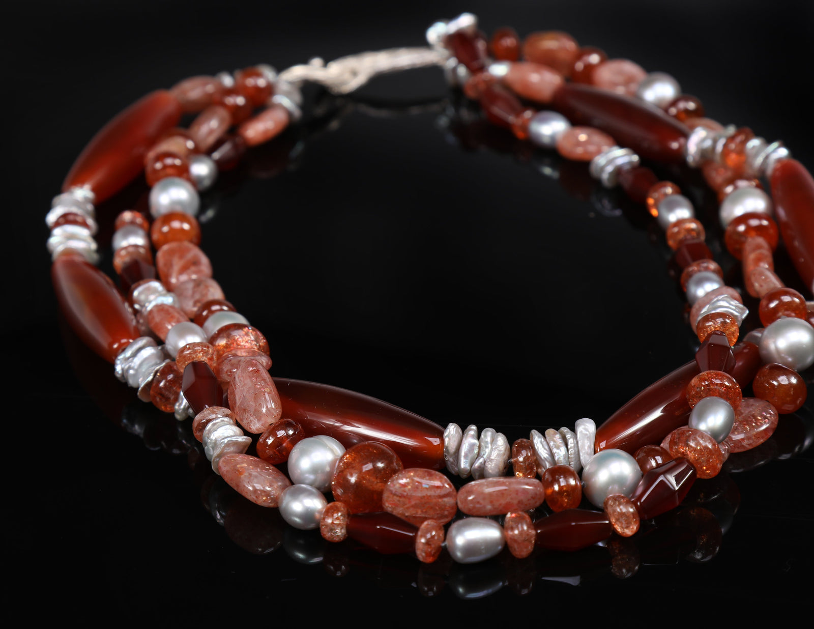 Sterling silver. Gems: carnelian, sunstone, and silver freshwater pearls. White Orchid Studio’s vanilla bean clasp. Approximate length: 18”