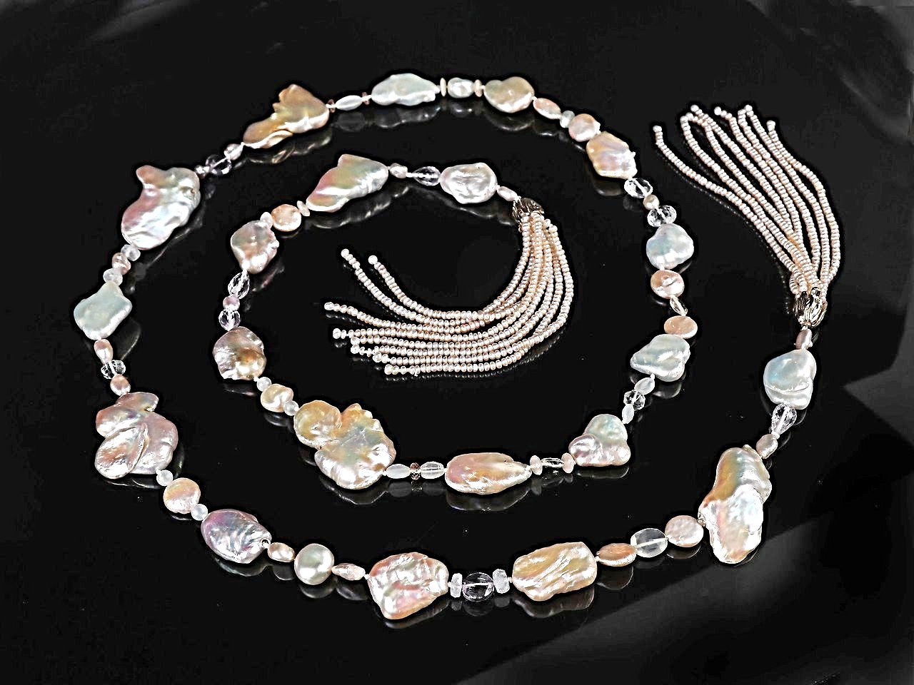 14kt yellow gold. Gems: blush pink, freshwater Keshi pearls, light amethyst, moonstone, and Oregon sunstone. Two tassels feature button pearls. White Orchid Studio’s floral bead clasp. Approximate length: 56”