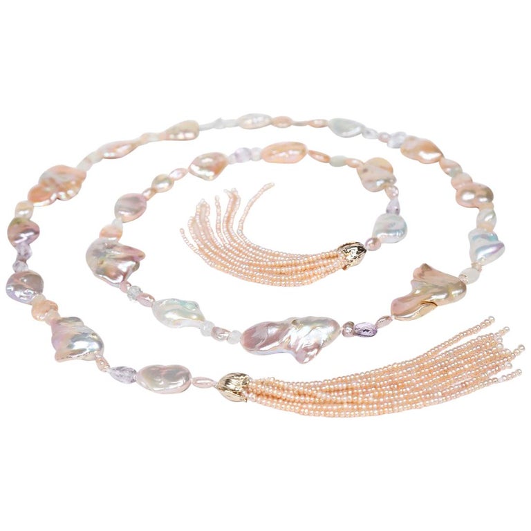 14kt yellow gold. Gems: blush pink, freshwater Keshi pearls, light amethyst, moonstone, and Oregon sunstone. Two tassels feature button pearls. White Orchid Studio’s floral bead clasp. Approximate length: 56”