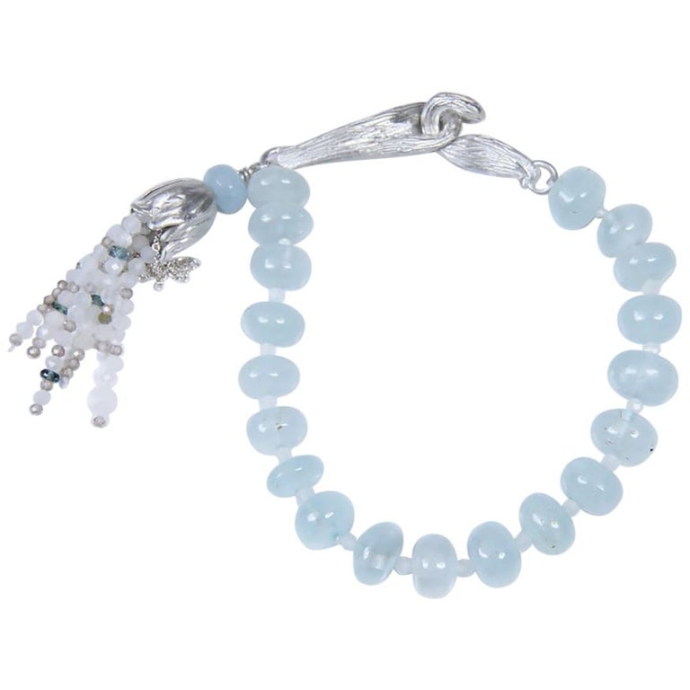Sterling silver and gem bracelet.  Gems: aquamarine and moonstone.  White Orchid Studio vanilla bean clasp and floral bead cap.  Approximate length 6.75."  