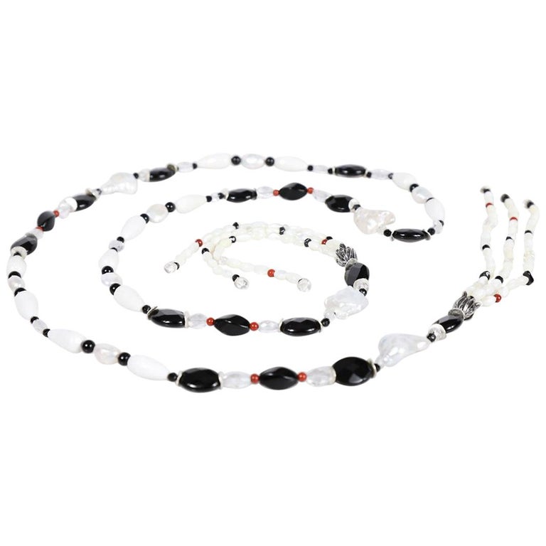 Sterling silver.  Gems: pearl, onyx, agate, quartz, and jasper. White Orchid Studio’s floral bead cap.  Approximate length 56.”