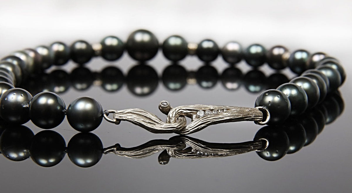 14kt white gold.  Gems:  black Tahitian pearls (10-14.5mm) and diamonds (.53 ct. approximate total weight).  "Night of a Thousand Stars" necklace embellishes White Orchid Studio's vanilla bean clasp and 6 vanilla bean rondelles with diamonds. 18.5”