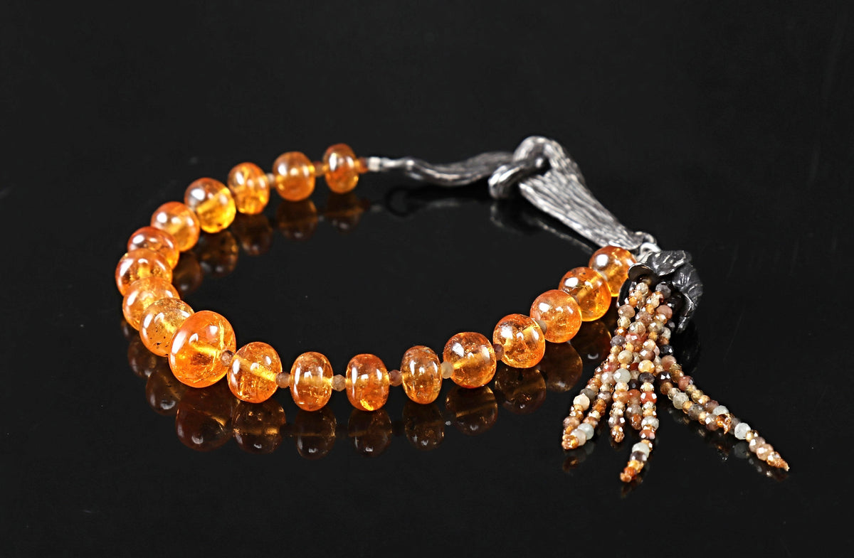 A mandarin garnet and orange sapphire bracelet. Sterling silver, vanilla bean clasp and bead cap antiqued with black max to enhance the texture. 7.5”